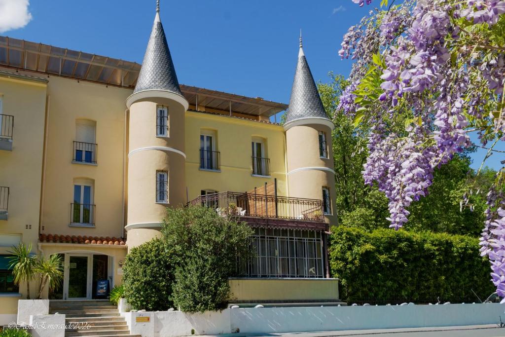 a large yellow building with turrets at Appart'Hotel-Restaurant Castel Emeraude in Amélie-les-Bains-Palalda