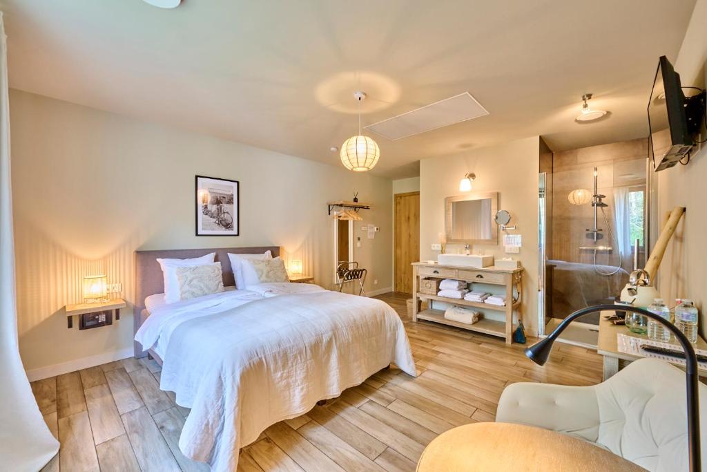 a bedroom with a large bed and a bathroom at B&B Rosteline in Hamont