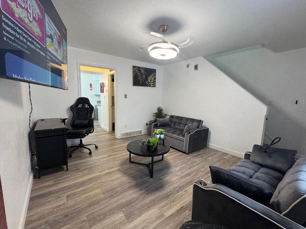 a living room with a couch and a table and a desk at The Chautard Suite in Pueblo
