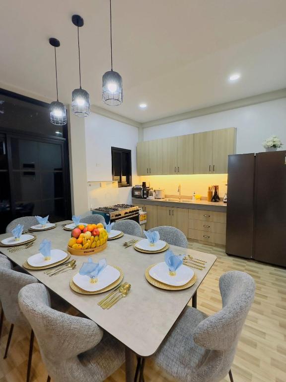 a dining room with a table with chairs and a kitchen at Villa Dietze in Davao City