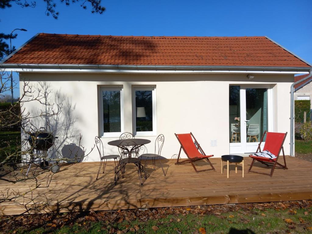 a deck with chairs and a table and a house at Rever la Saône in Rigny