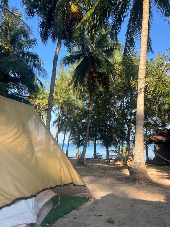 a tent on the beach with palm trees at Maya Sunset Room, Coral Bay Perhentian Island in Perhentian Island