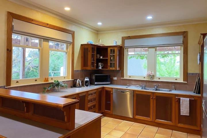 a large kitchen with wooden cabinets and stainless steel appliances at Hidden Getaway in the City in Mount Gambier