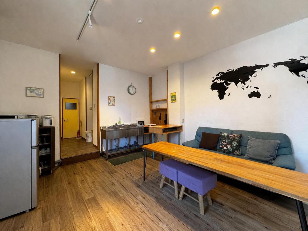 a living room with a blue couch and a world map on the wall at NUPURI in Otaru