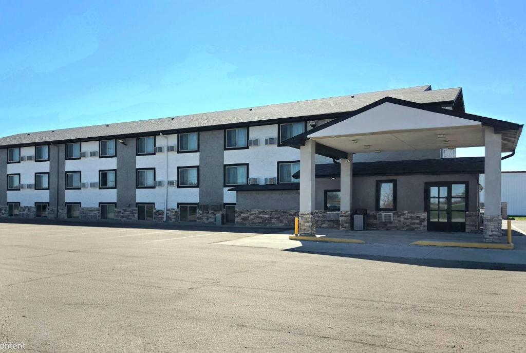 a large building with a parking lot in front of it at Super 8 by Wyndham Yankton in Yankton