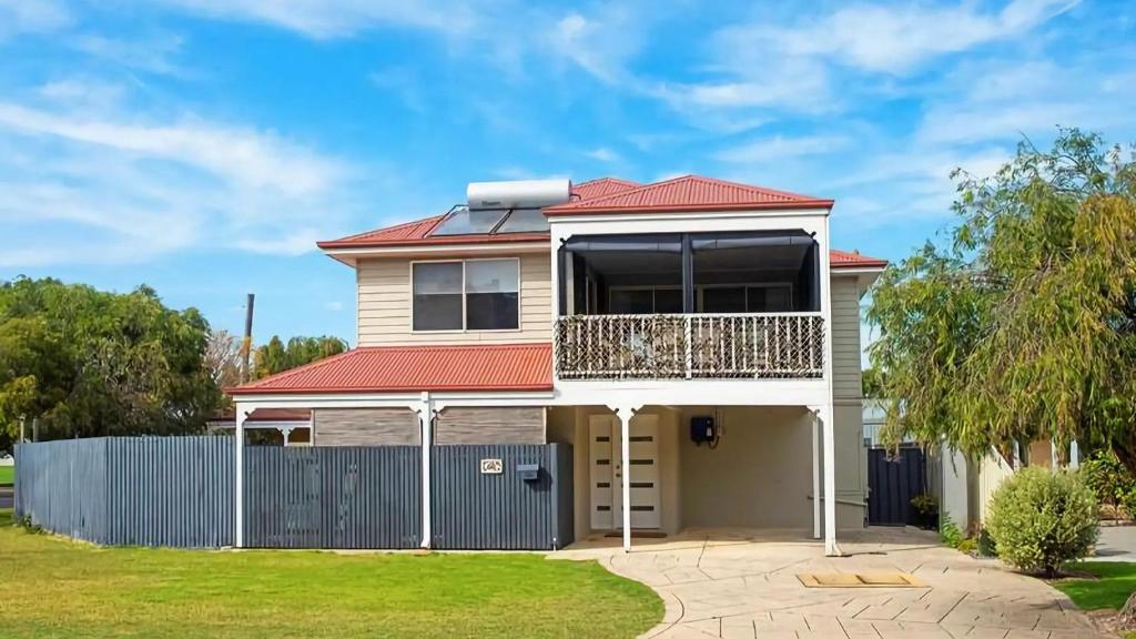 a house with a red roof and a fence at Studio 66 Busselton in Busselton
