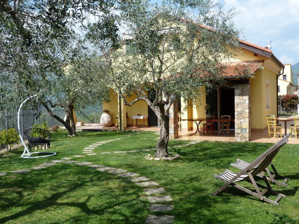 a garden with a bench and trees and a house at La Testa Fra Le Nuvole in Finale Ligure