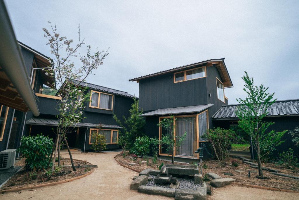 a home with a black house with a courtyard at ホテル聚 - Hotel SHU in Tonosho