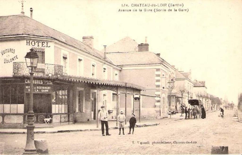 uma foto antiga a preto e branco de uma rua com edifícios em Hotel de la gare em Château-du-Loir