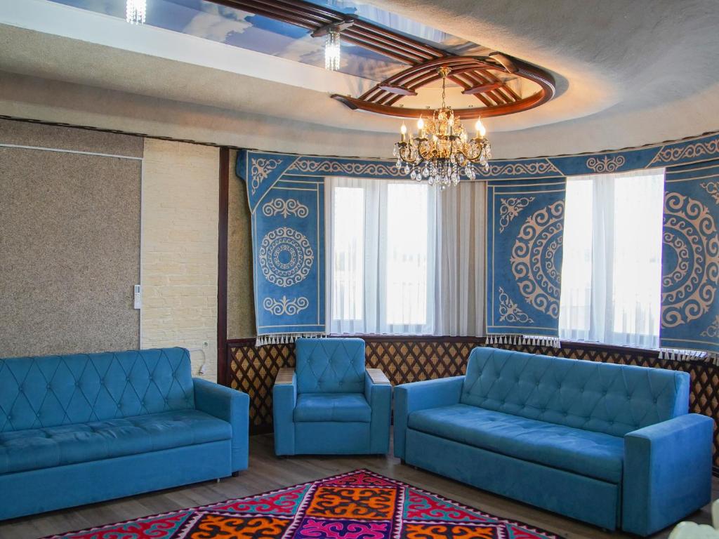 a waiting room with blue couches and windows at Dolon Hostel in Bishkek