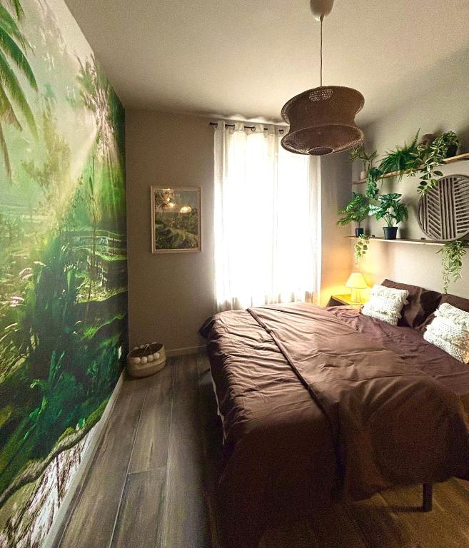 a bedroom with a bed and a large painting on the wall at Expérience Balinaise à Amiens in Amiens