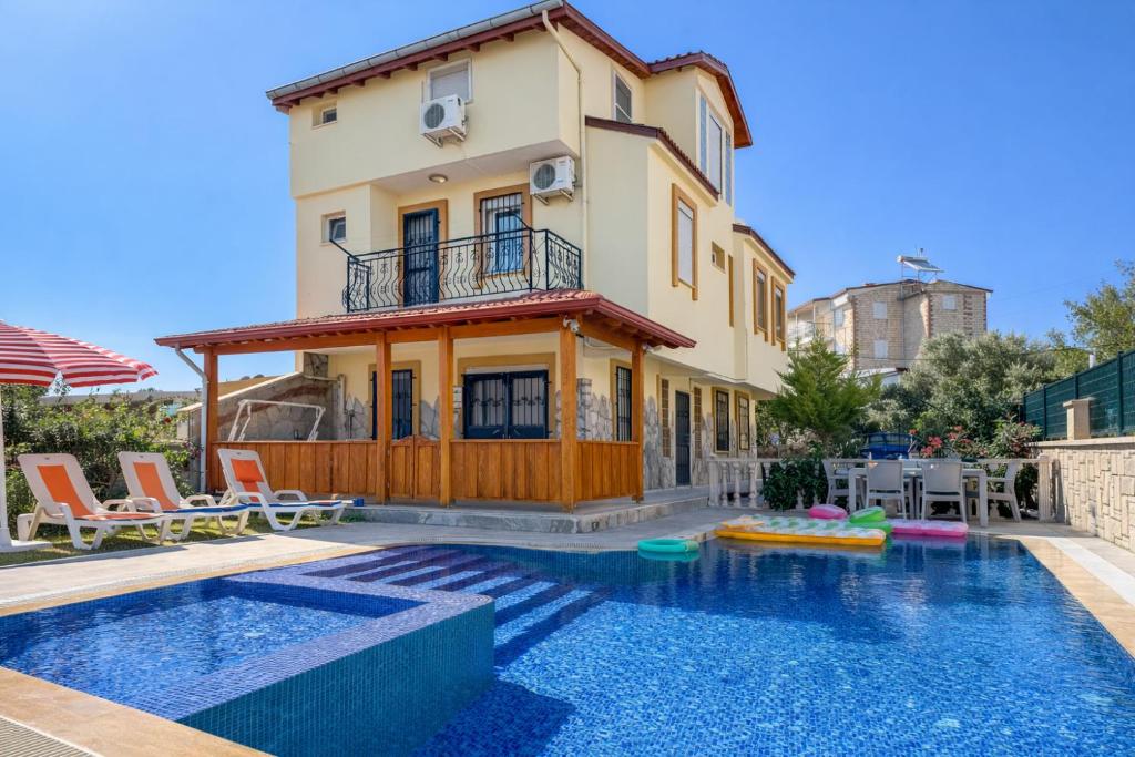 a villa with a swimming pool and a house at Villa Elma in Kuşadası