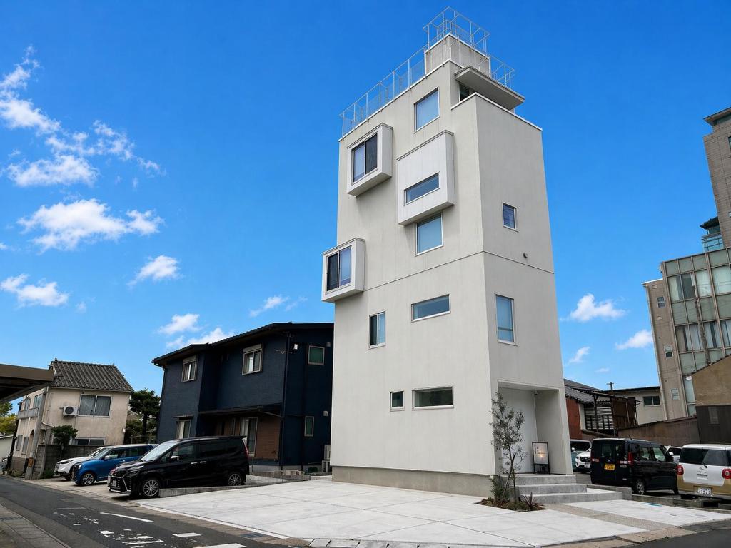 a tall white building on the side of a street at 塔の宿 宍道湖 in Matsue