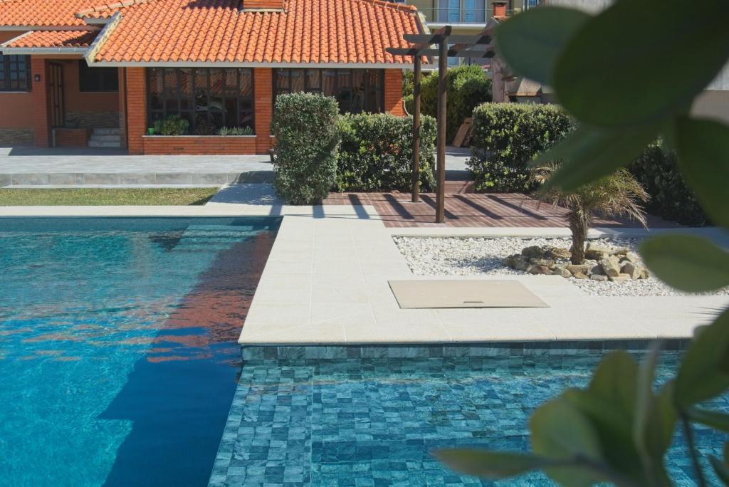 a swimming pool in front of a house at OLA Guesthouse in Esmoriz