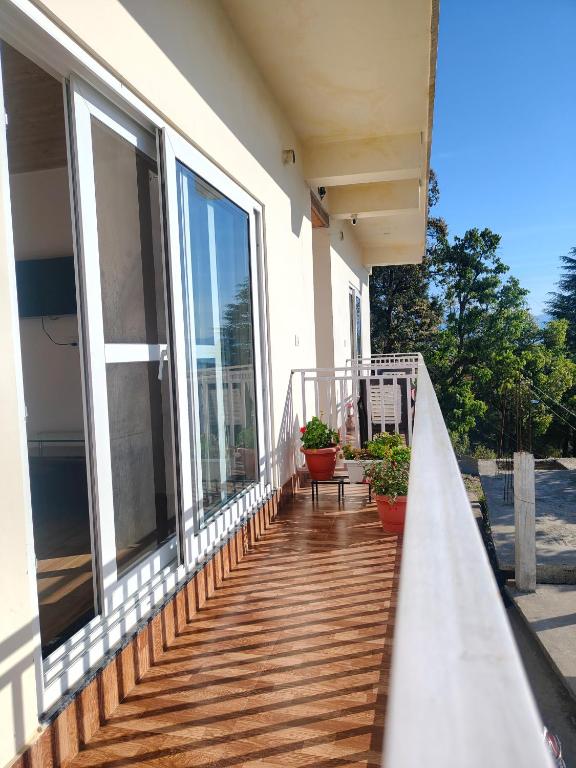 a balcony of a house with windows and plants at Saadhan Homestay in Mussoorie