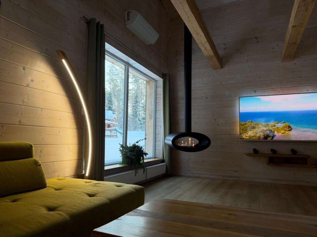 a living room with a couch and a flat screen tv at ForrestVila in Karačiūnai
