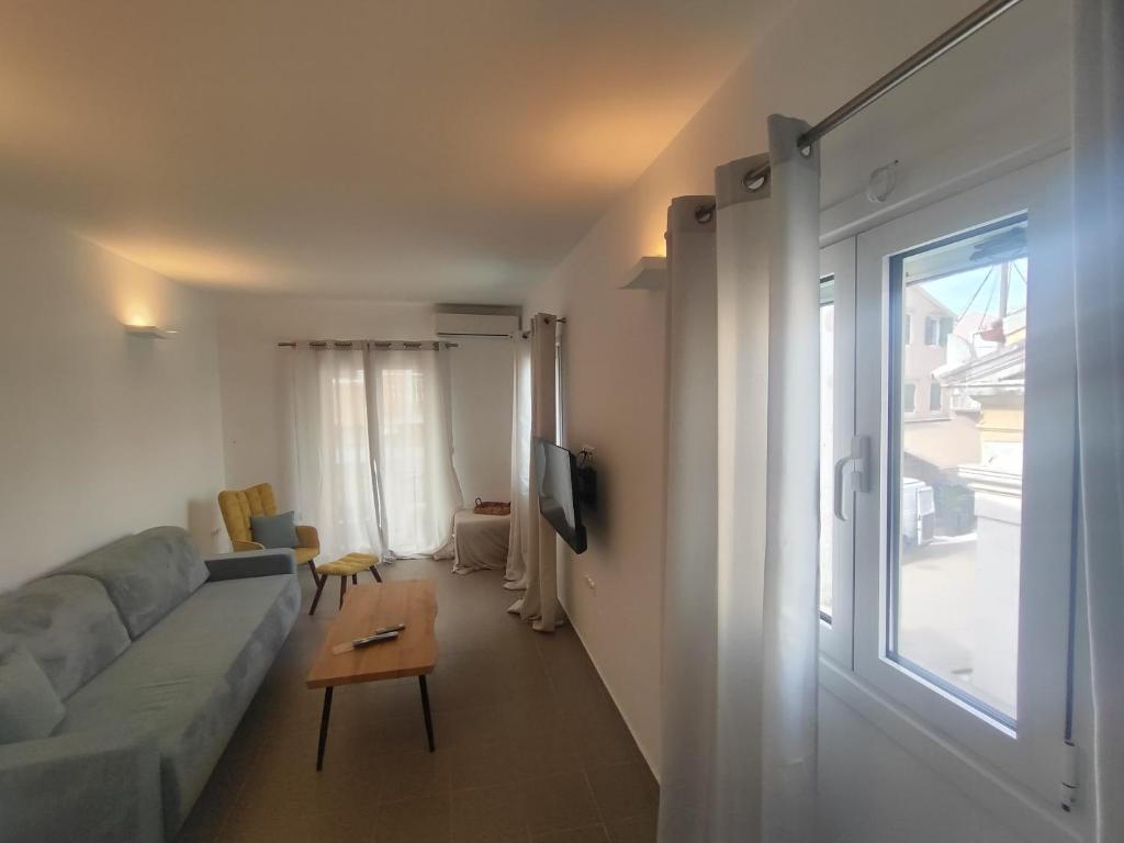a living room with a couch and a window at Piazza di Lefkimmi in Lefkimmi