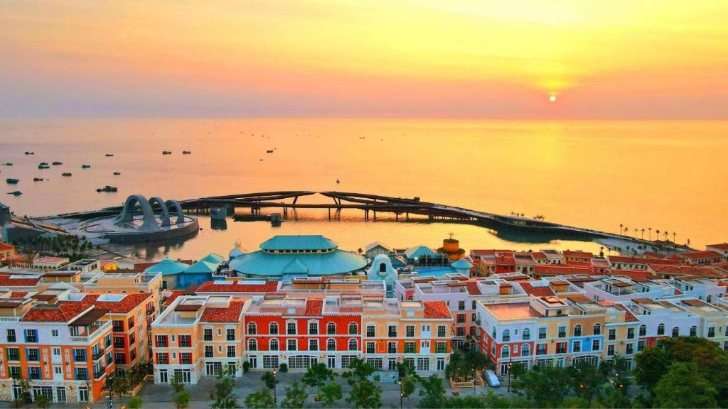 an aerial view of a city at sunset at HUB MULTI 3 HOTEL - Sea & Firework View in Phú Quốc