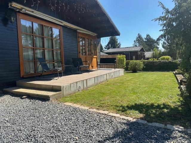 a house with a porch with two chairs on it at La tanière du ptit Lou in Resteigne