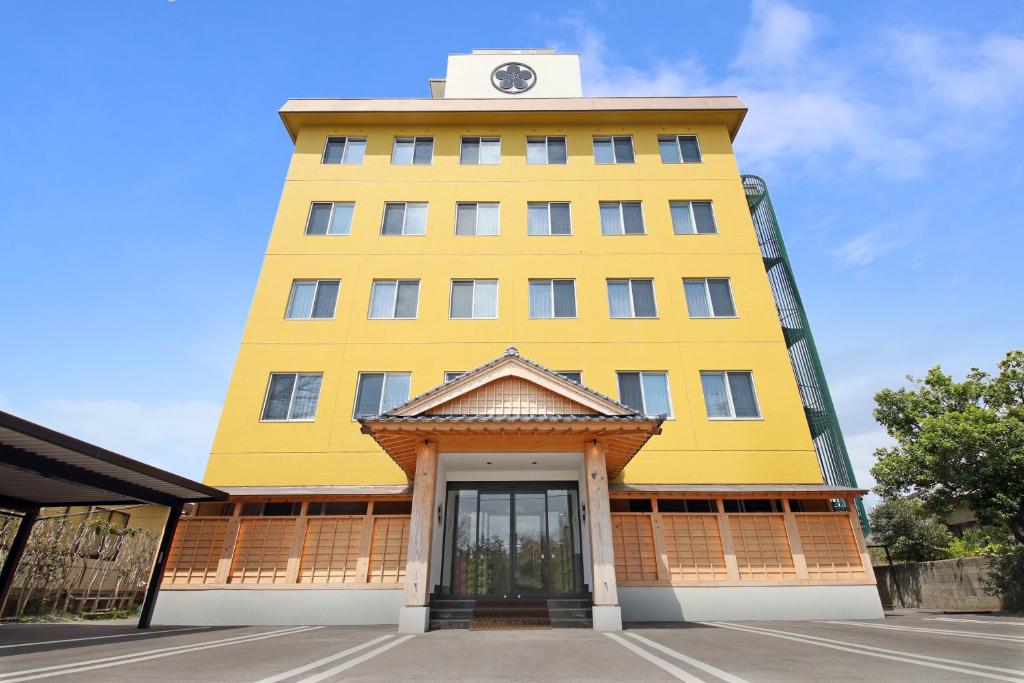 a yellow building with a clock on top of it at Gogaku Hotel in Aso