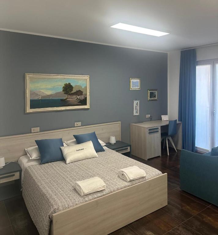 a bedroom with a bed with blue walls and a desk at B&B Caricone in Orta Nova
