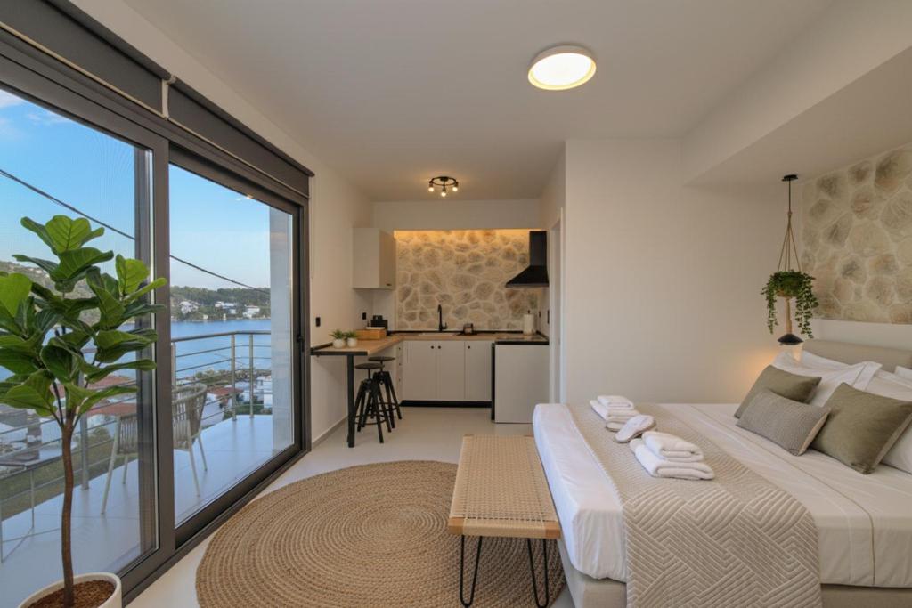 a bedroom with a bed and a kitchen with a balcony at kallos of Skiathos in Skiathos