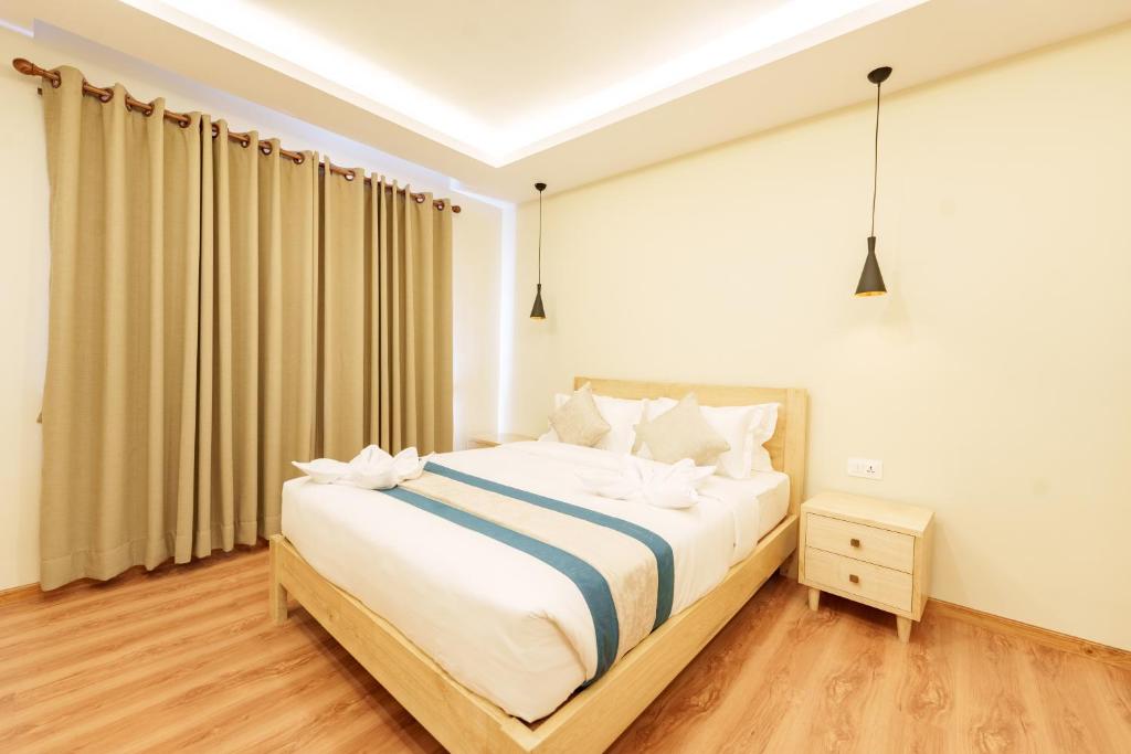 a bedroom with a large bed with white sheets at Mandala Living Kathmandu in Kathmandu