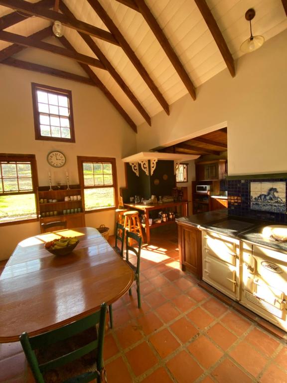a kitchen with a wooden table and a dining room at Stoneygate Farm in Wakkerstroom