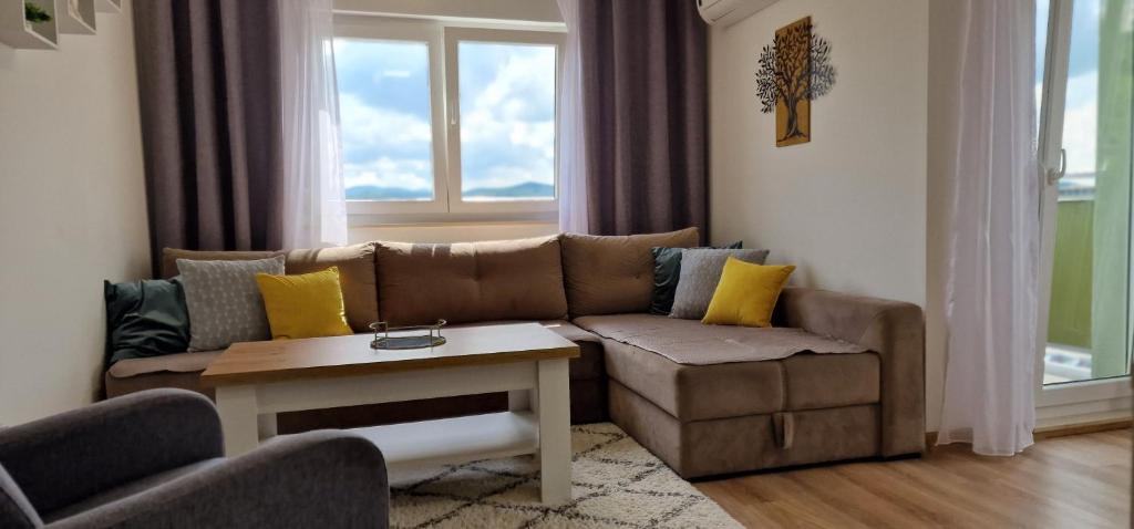a living room with a couch and a table at Opal Skay Apartment in Doboj