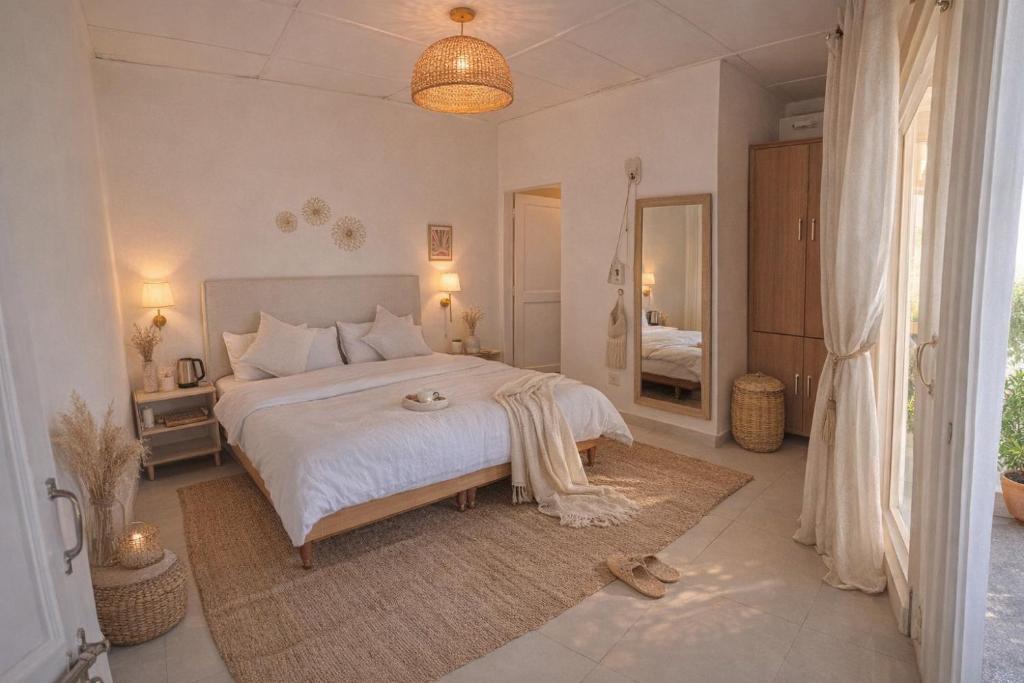 a bedroom with a large white bed and a mirror at Bir Haus in Bīr