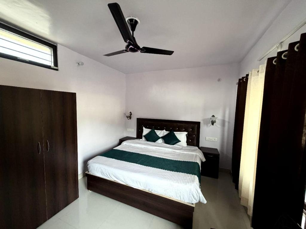 a bedroom with a bed with a ceiling fan at Rautela Homestay in Lansdowne