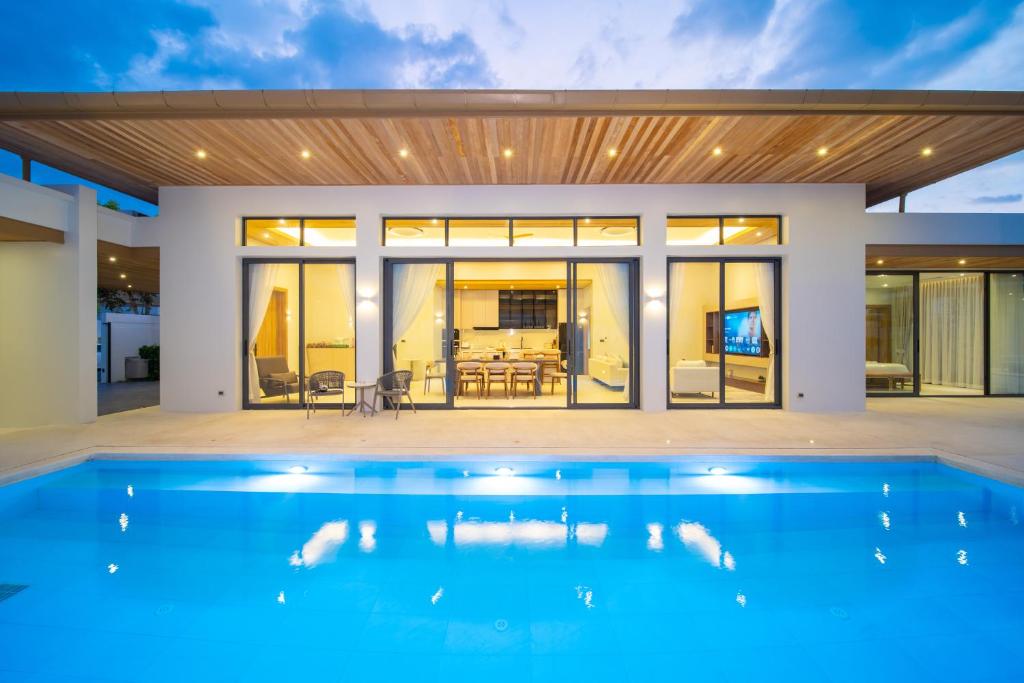 a swimming pool in front of a house at Mouana Breeze Mai Khao VIP 4-bedroom Pool Villa 9911 in Phuket