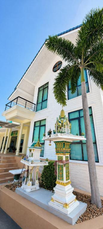 a building with a palm tree in front of it at CenterPoint Thong Sala in Thong Sala