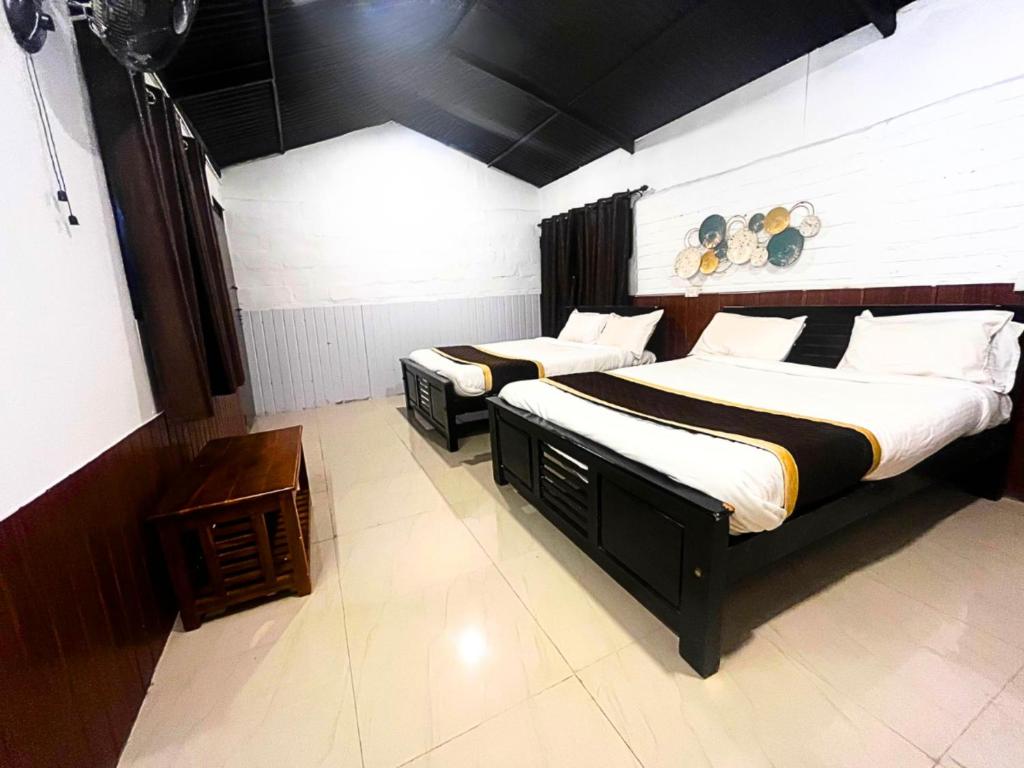 two twin beds in a room with at Resort Rover - Sampala in Masinagudi