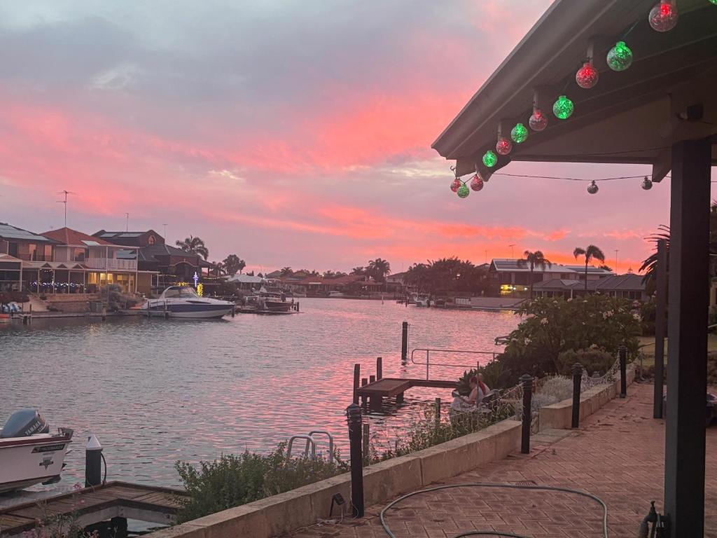 a sunset over a body of water with boats at Waterside Hideaway in Mandurah