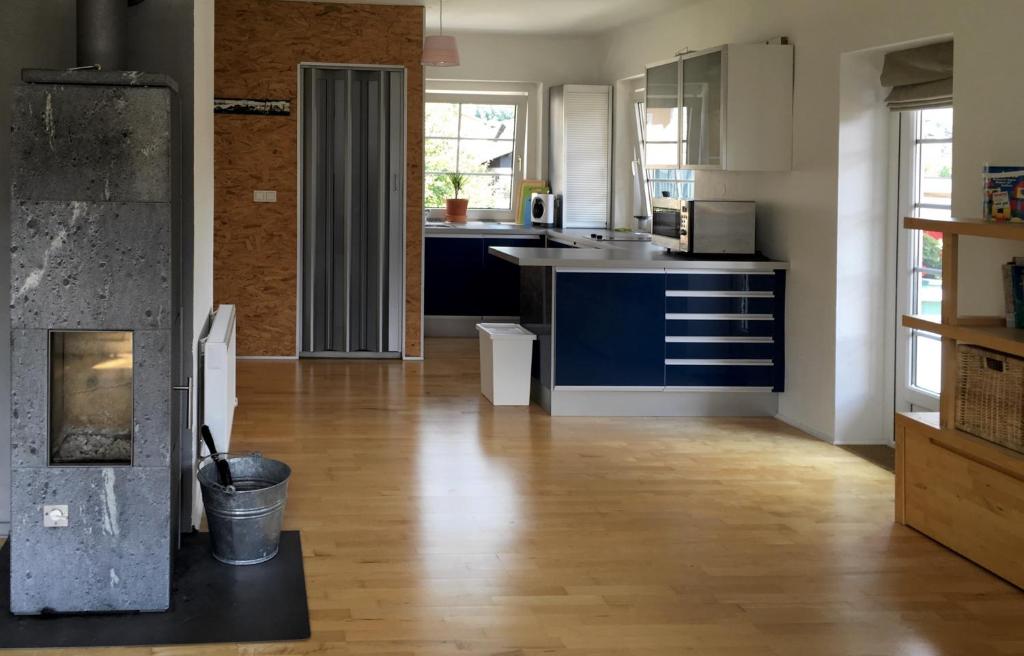 Il comprend une cuisine avec des placards bleus et du parquet. dans l&#39;établissement Apartment Haus Wieser, à Gröbming