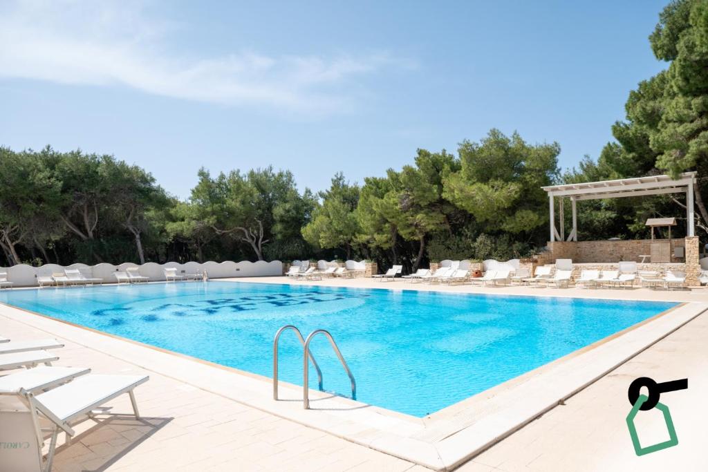 a large swimming pool with lounge chairs and a resort at Hotiday Gallipoli Spiaggia in Baia Verde