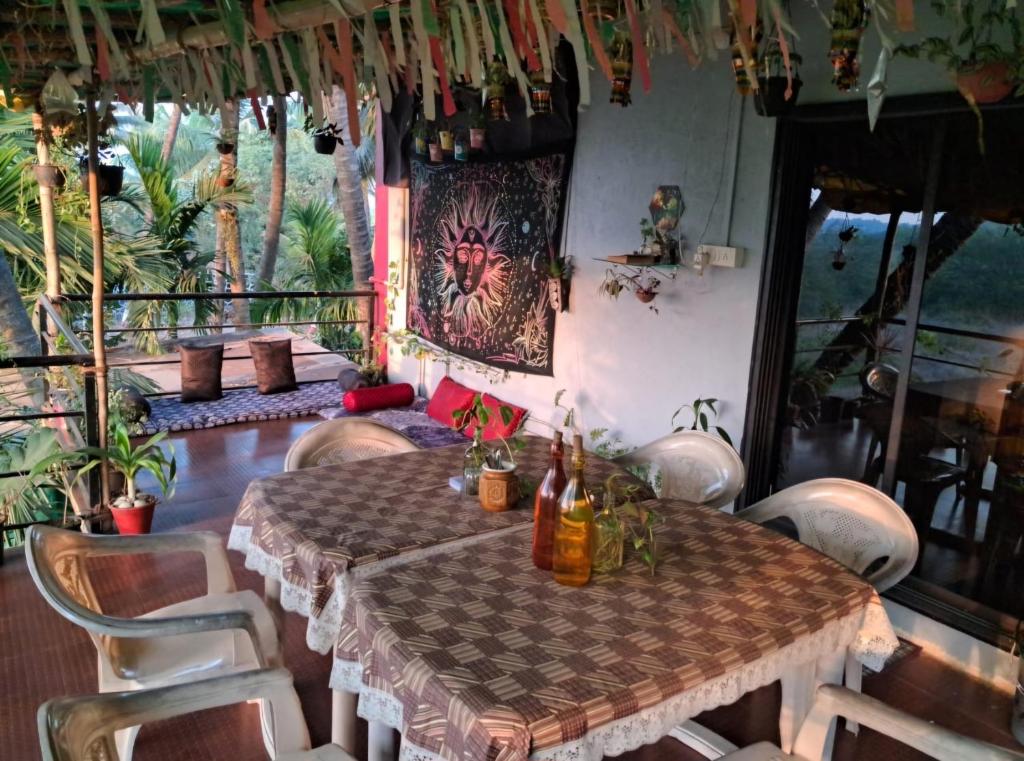 a table and chairs in a room with a table at Bageecha B&B- V A A Y U in Alībāg