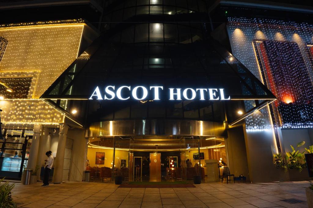 a man stands outside a asot hotel at night at Ascot Hotel in Kozhikode
