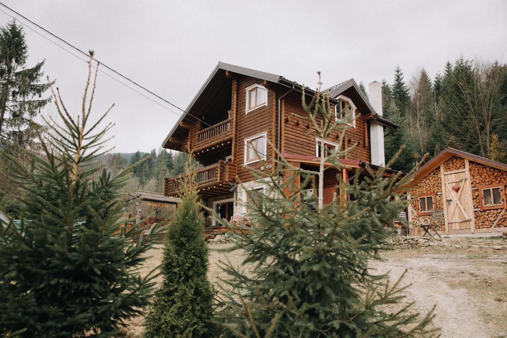 a log house with trees in front of it at Vidal in Tatariv