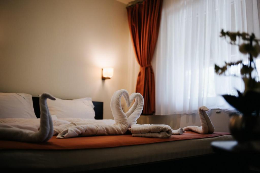 a bedroom with a bed with towel animals on it at Complex Turistic Suatu in Suatul