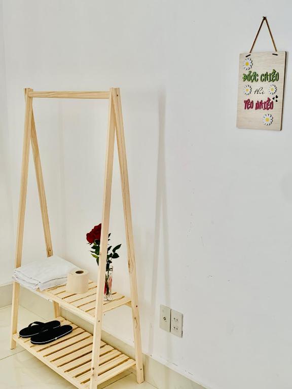 a wooden shelf with a plant in a room at Guest house Trung Hiếu in Rạch Giá