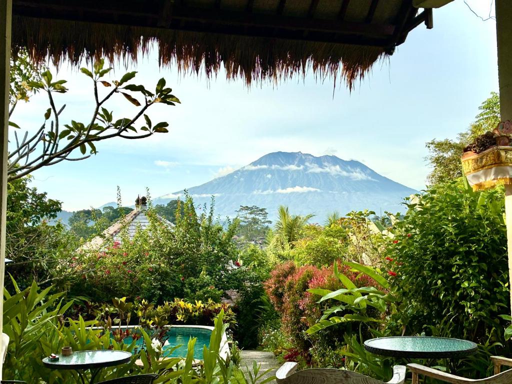 a view of a mountain from a garden with tables at Amrita Villa Sidemen in Sidemen