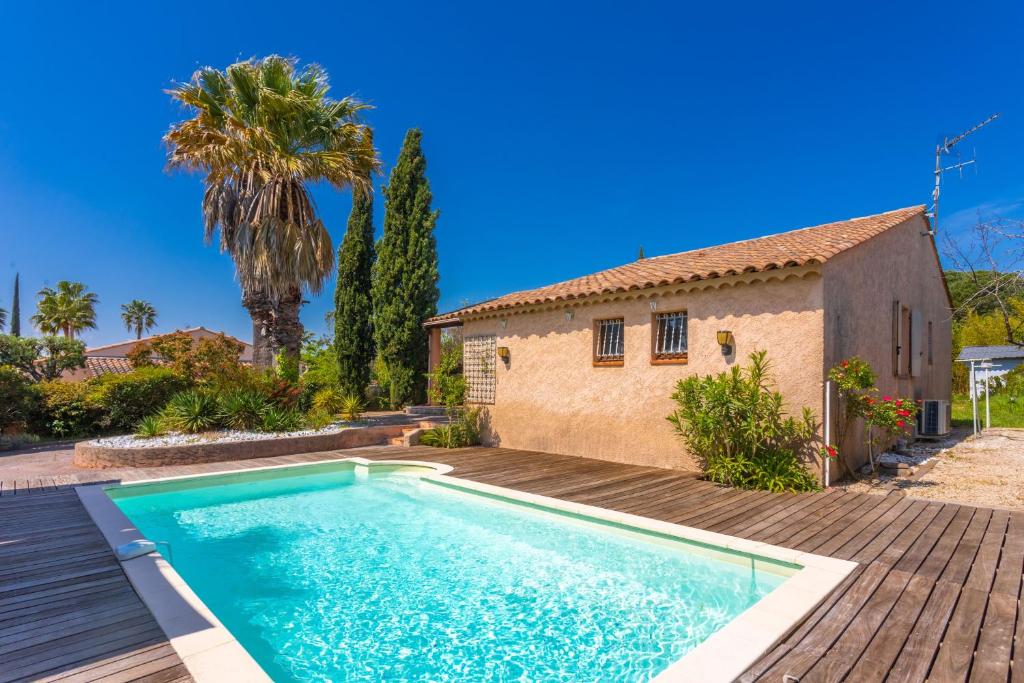 a swimming pool in front of a house at Villa 3 palmiers avec pisicne in Fréjus