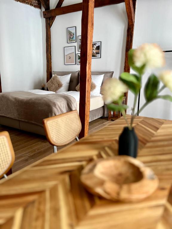 a room with a bed and a wooden table with a table sidx sidx at Loft in der Innenstadt von Fulda, 60qm, privater Eingang in Fulda