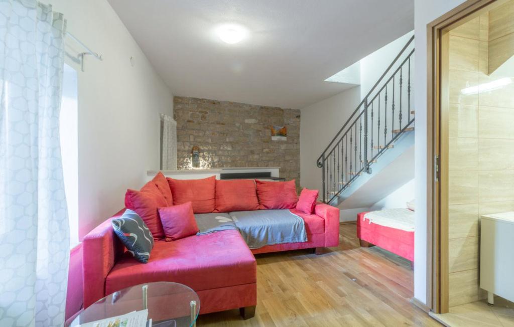 a living room with a pink couch and stairs at Marija's House in Bale