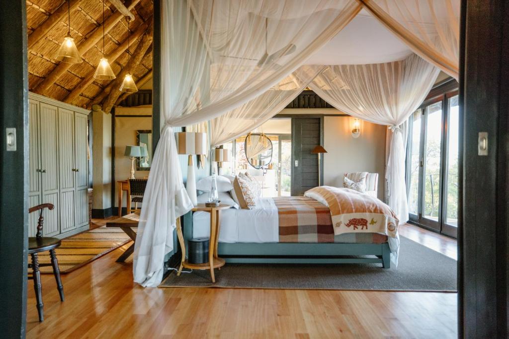 a bedroom with a canopy bed with curtains at Horizon by Ongava in Okaukuejo