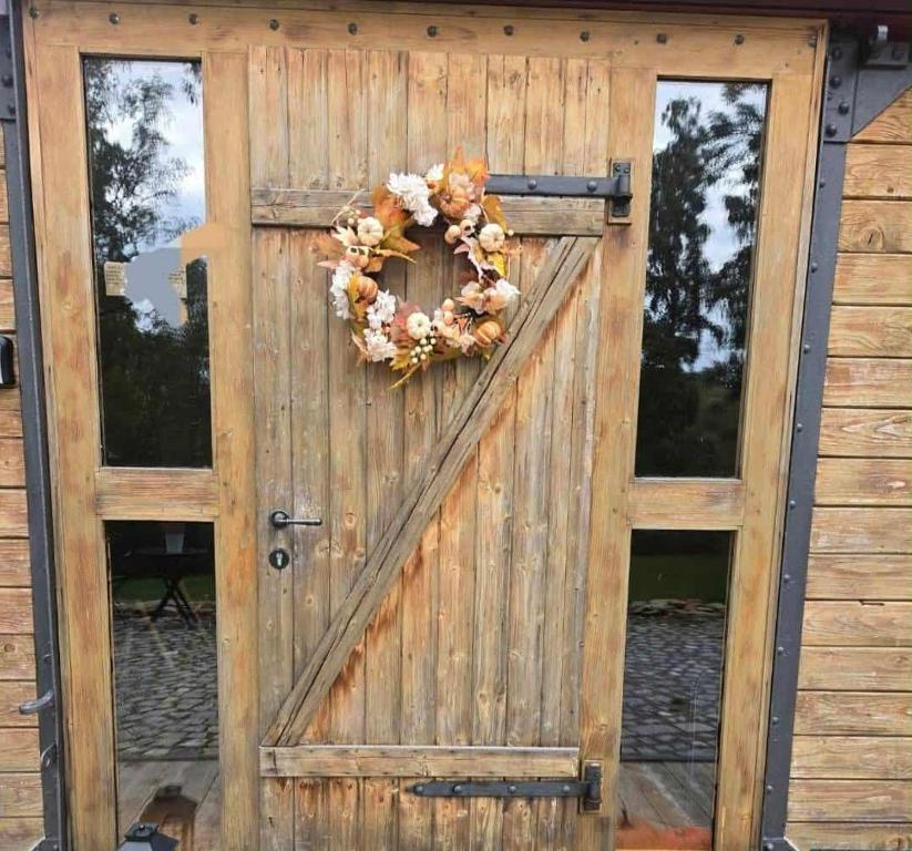 a wooden door with a wreath on it at Obytný vagón Bzová Běleč in Kamberk