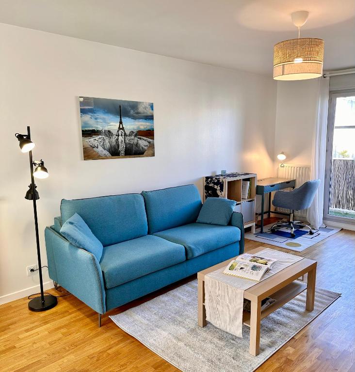 a living room with a blue couch and a table at Blue Harmony in Massy