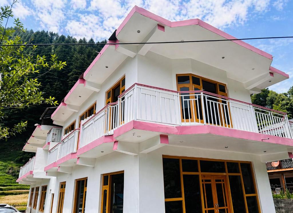 a white and pink house with a balcony at Barot Palace in Barot 